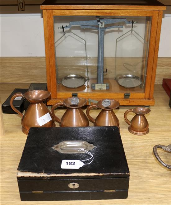 An Edwardian writing box, four copper measures and Scientific scales and weights